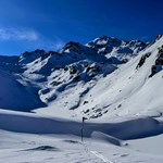 Skibergsteiger bei Durchquerung winterliche Ebene, am Horizont Bergketten